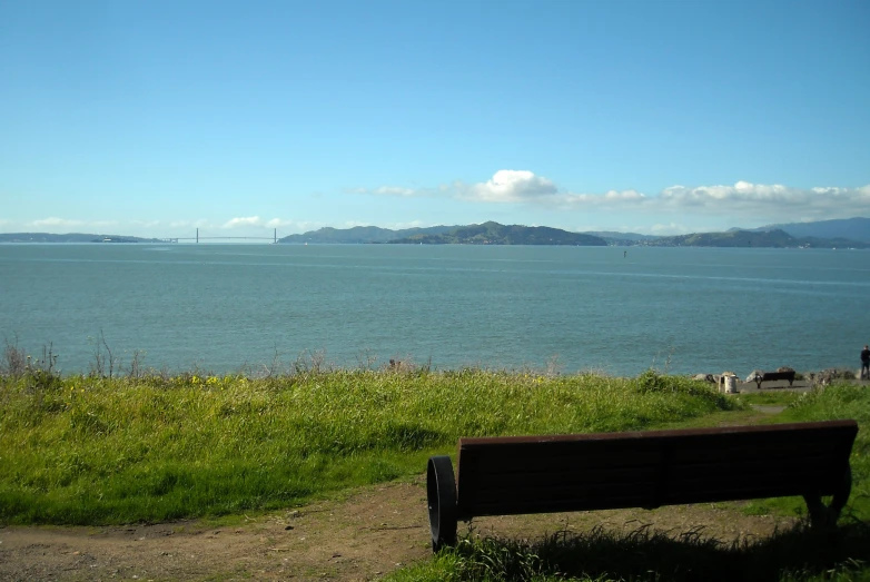 there is a bench on a hillside near the ocean