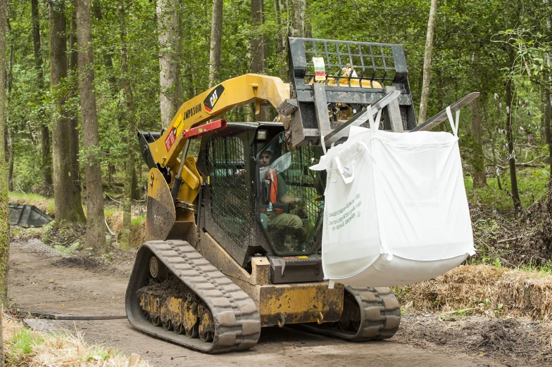 a bulldozer moves through the woods with supplies