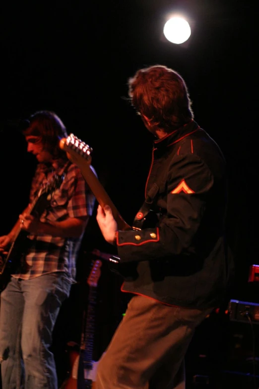 the young man is playing the guitar on the stage