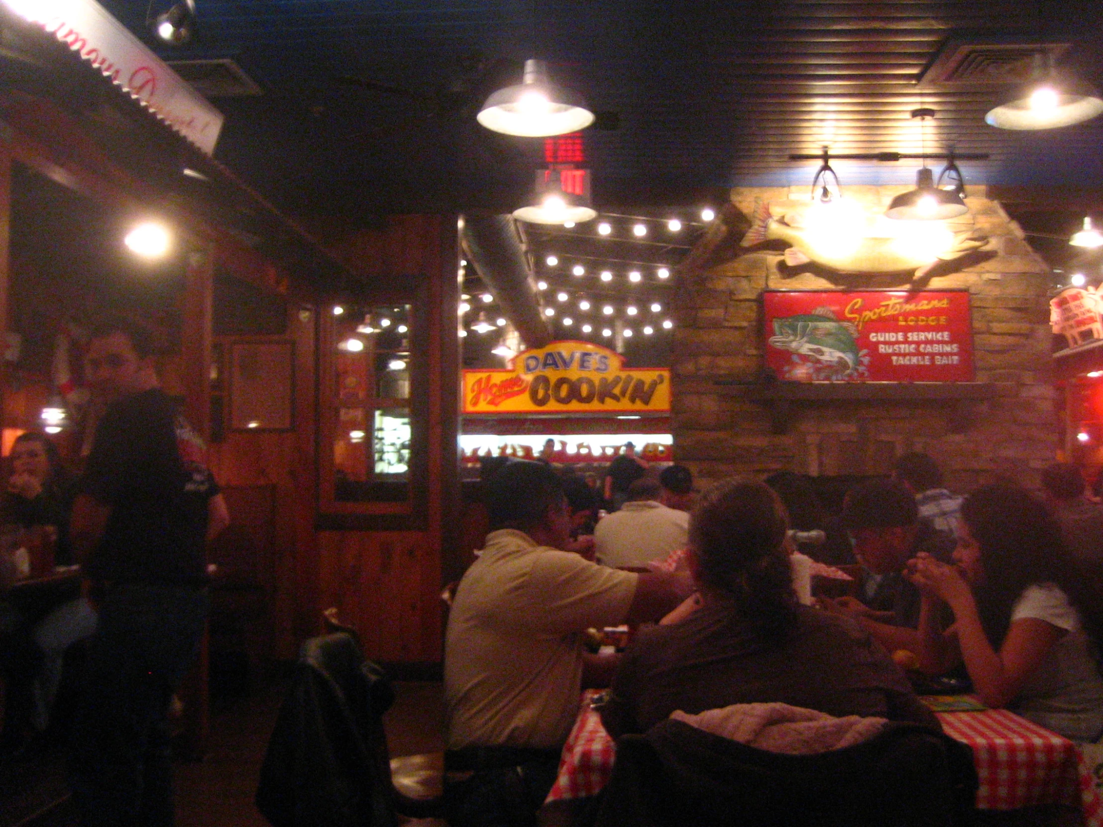 people eating at tables with lights in the background