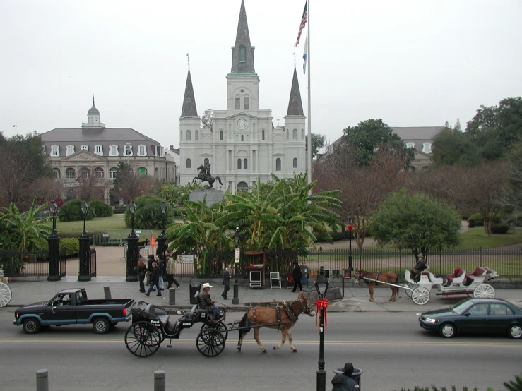 horse drawn carriages going through an intersection with cars