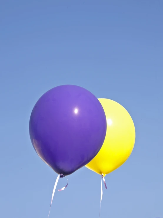 two balloons floating in the sky and two are blue