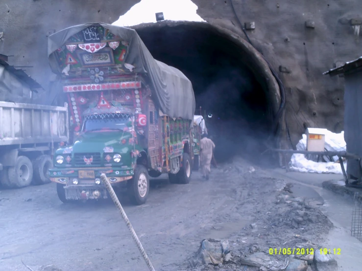 two large trucks parked outside of a dark tunnel