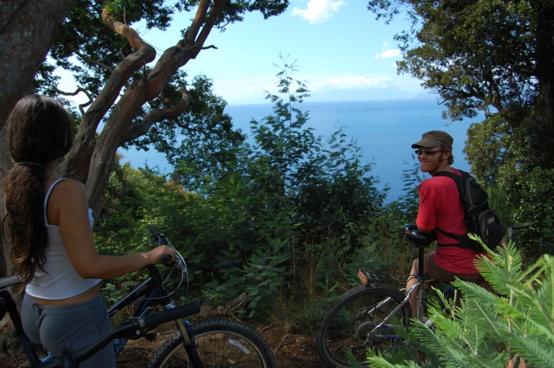 a man and a woman look out over a mountainous forest