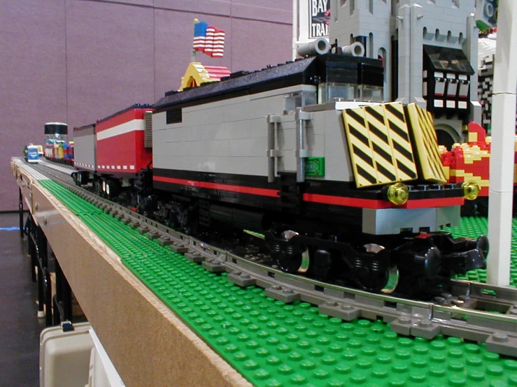 lego train on tracks with flag in background