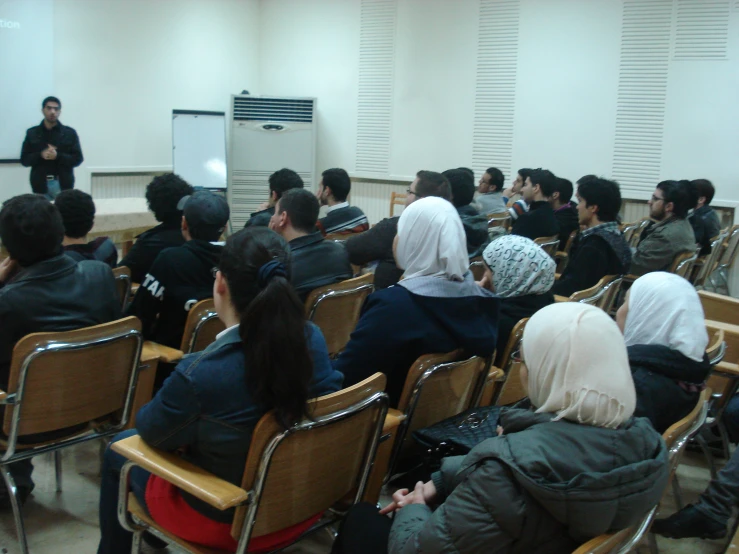 a group of people sit together at a lecture hall