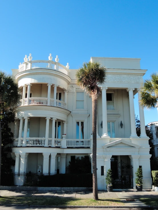 a beautiful white house with balconies and palm trees