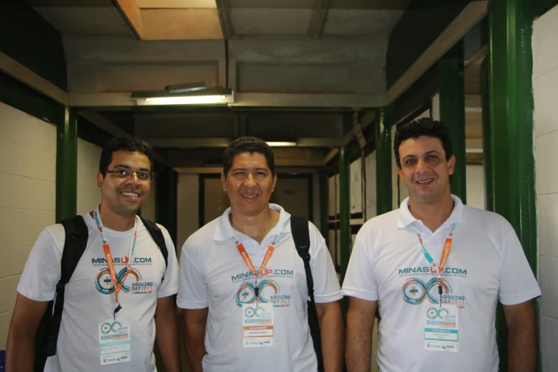 three men in white shirts and backpacks standing near each other