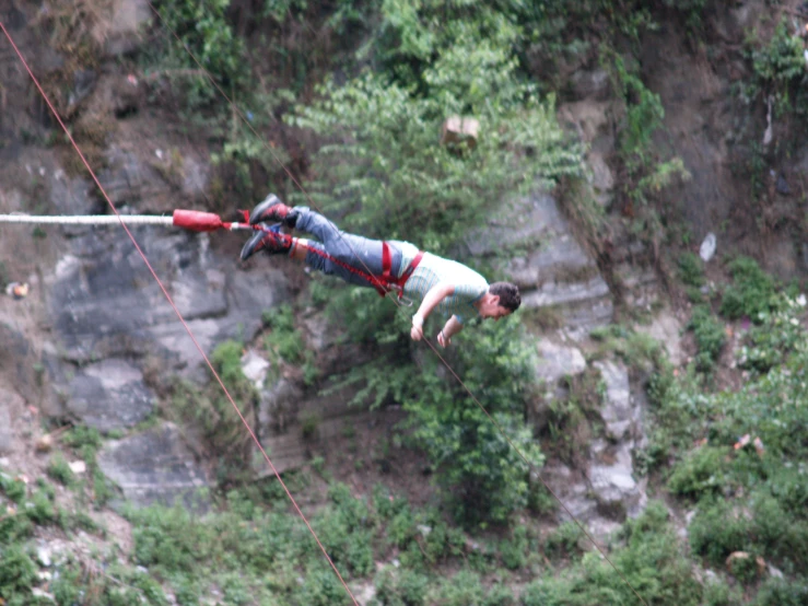 a man hanging from the ropes by climbing