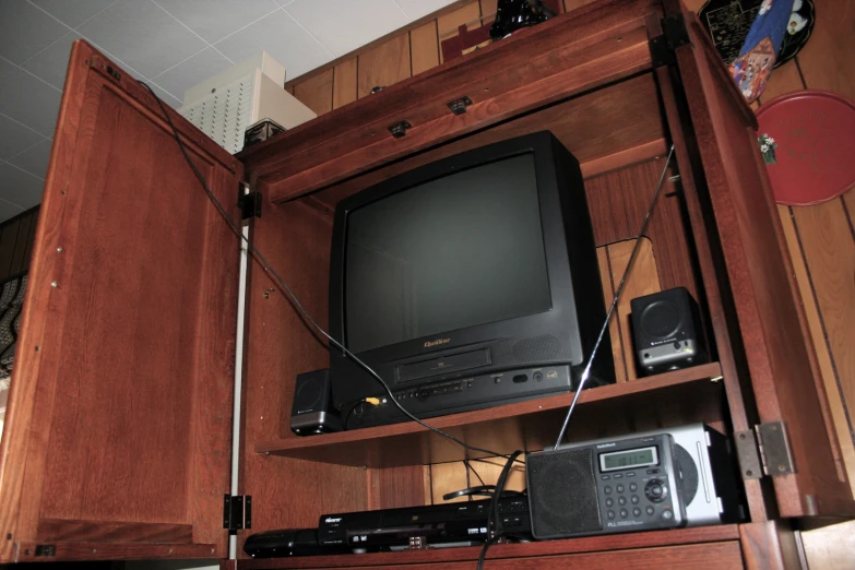 a tv and speakers in a corner on wooden cabinets