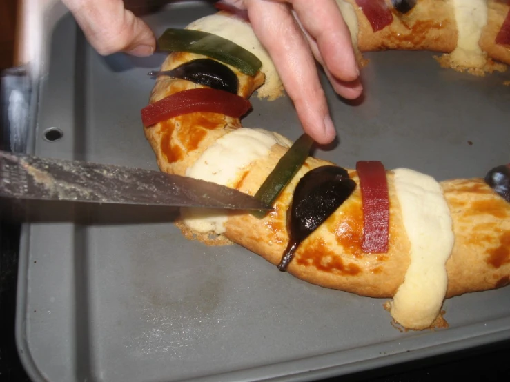 hands taking pizza slices out of a pan