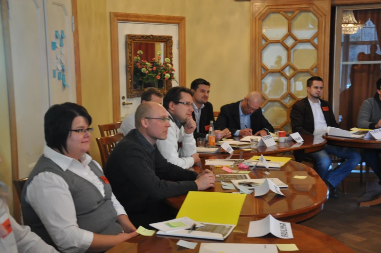 a group of people are sitting around a conference table