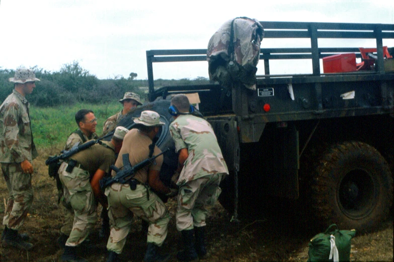 several men are standing in front of an army truck