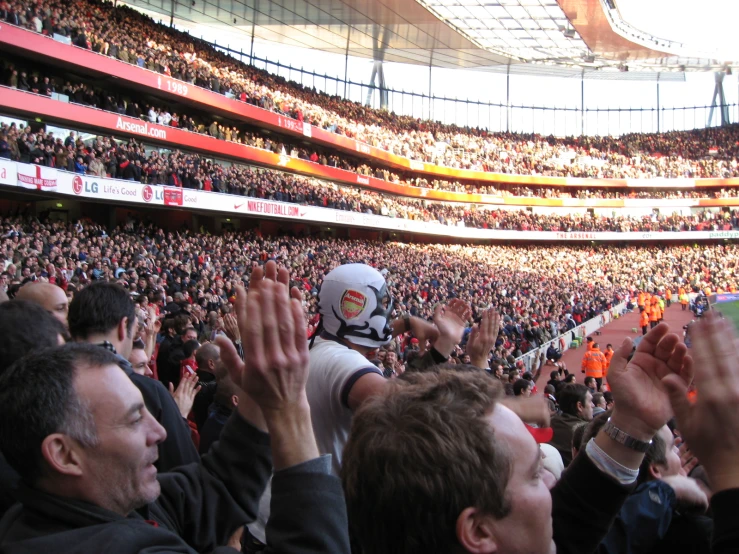 a stadium full of people with their hands up in the air