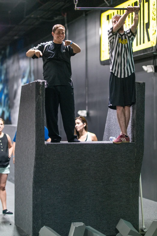 two men on top of a set of speakers