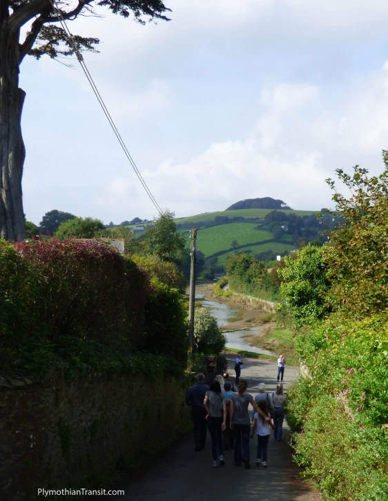 a group of people walk down a narrow road