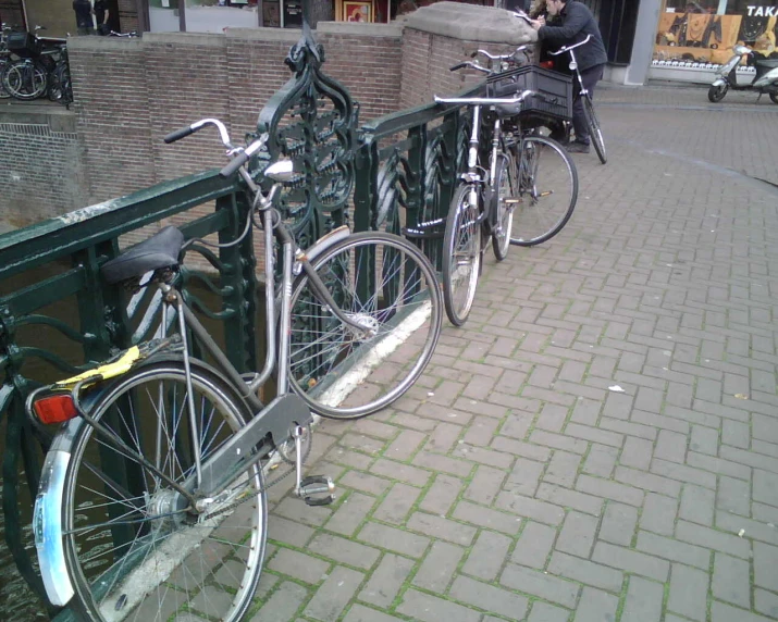 two bicycles are parked next to each other on the railing
