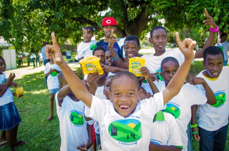 a group of children in white shirts holding their bags of cereal