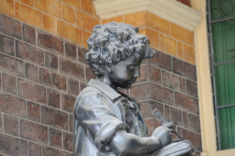 statue of a man with a book and a cell phone