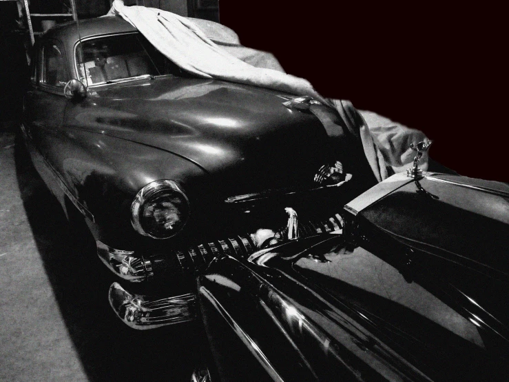 black and white po of an old car parked in the driveway