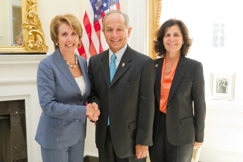 three people are standing in front of an american flag