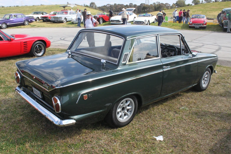 an old - fashioned green car parked next to another old one