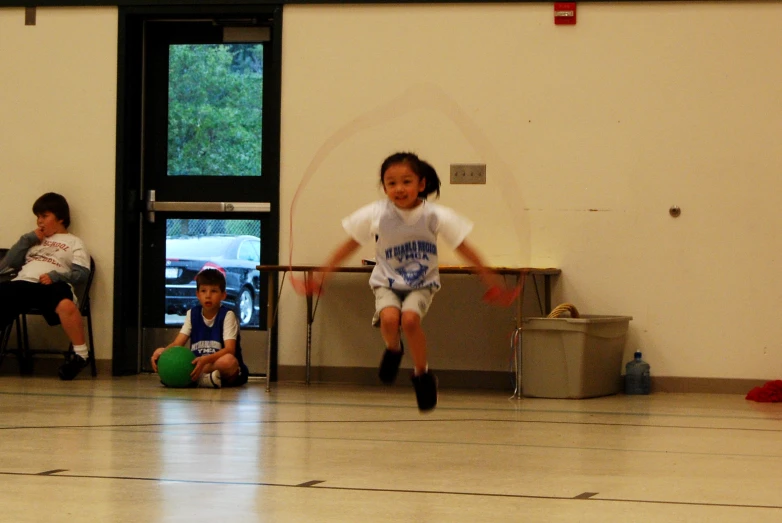 an image of young child playing basketball with friends