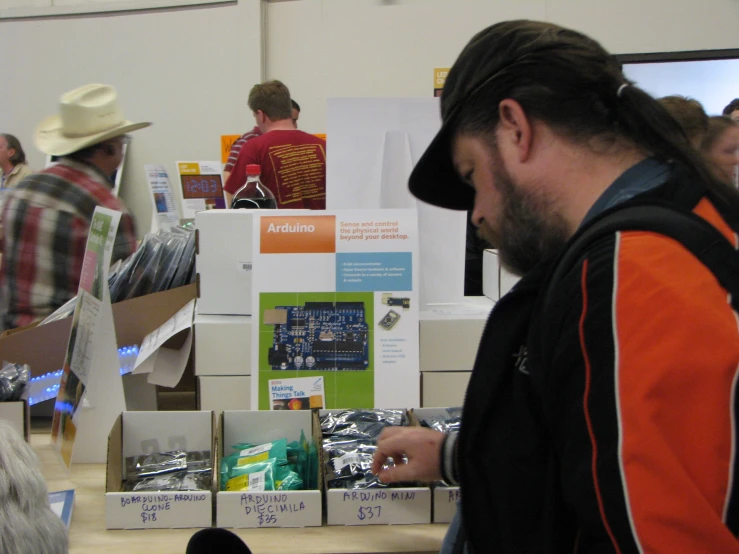 man in plaid hat shopping for items at a craft store