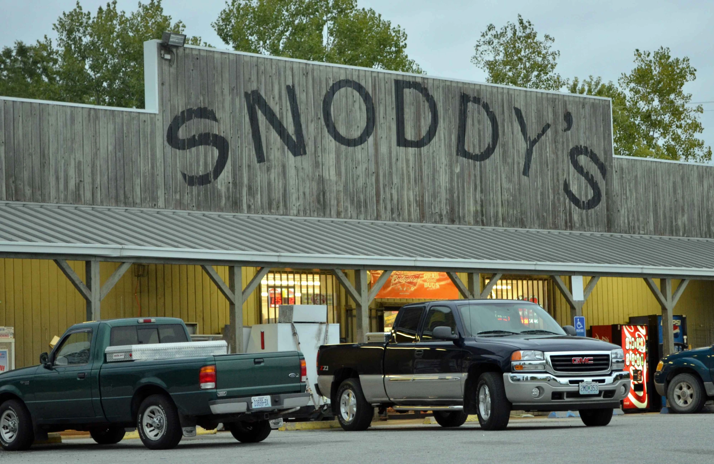 two pickup trucks parked in front of a store