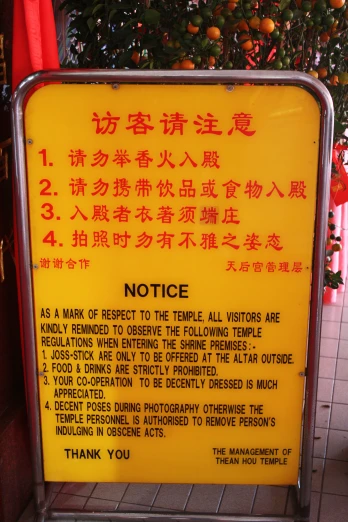 a yellow notice sign on a metal stand