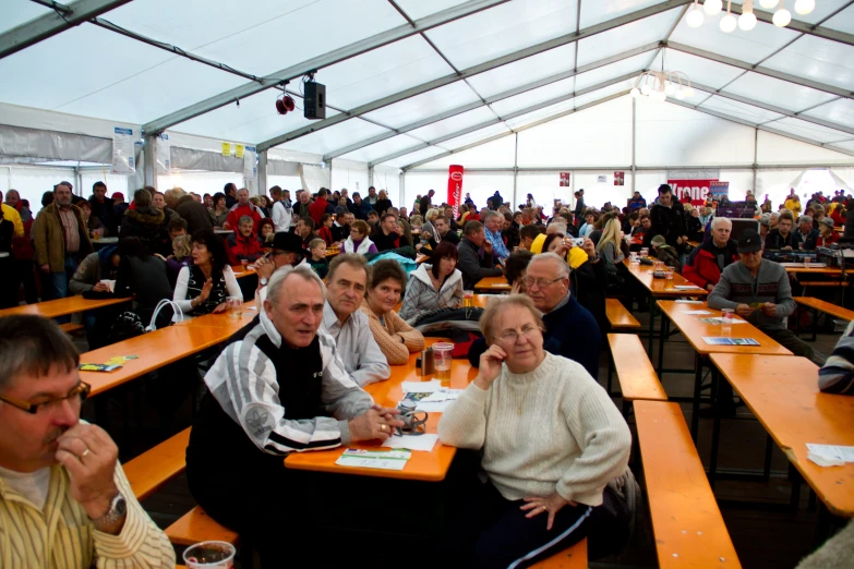 a large crowd of people are sitting in an orange tent