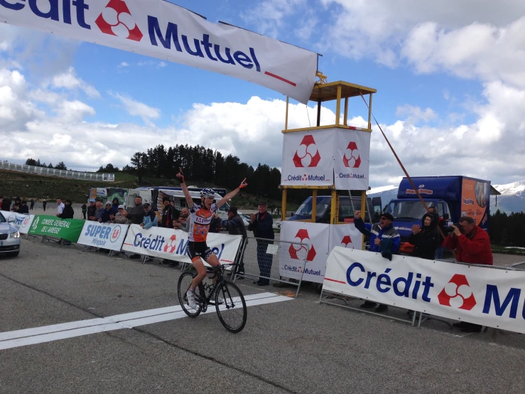 a woman is on her bike waving at the crowd