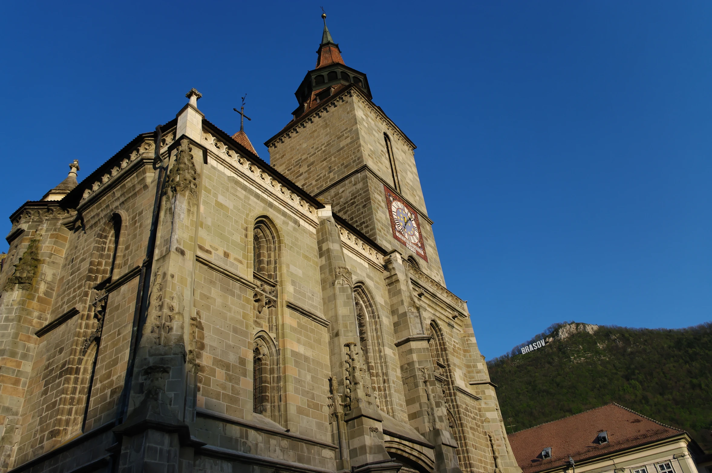 a gothic church with clock on steeple with blue sky