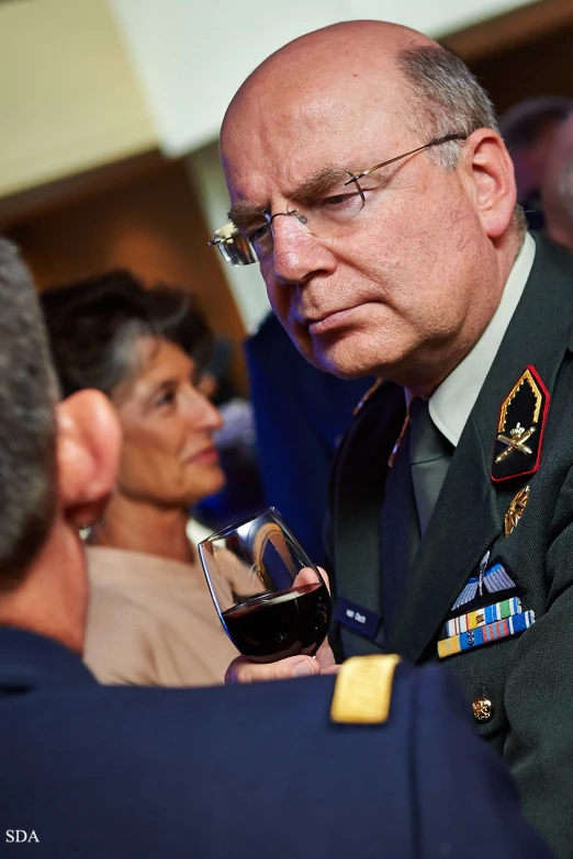 a man in a military uniform holds a glass