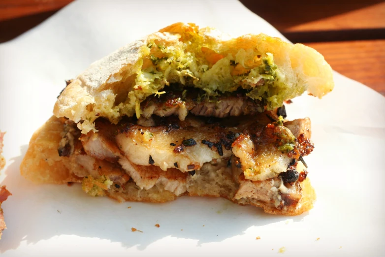 a sandwich is stuffed with meat, sauce and vegetables