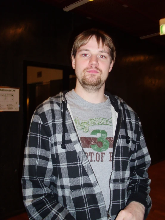 a man in plaid jacket holding a donut