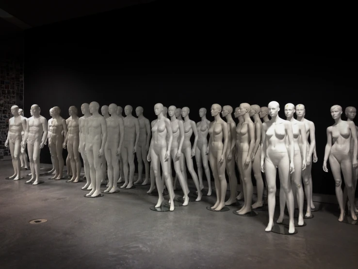 a large group of white plastic male mannequins