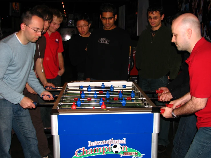 several men are playing with a foosball game