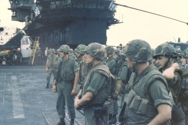 military personnel wearing uniforms and uniforms stand near the boat