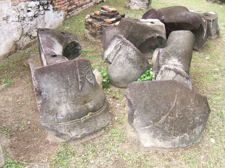 a pile of grey rocks sitting on top of grass covered ground