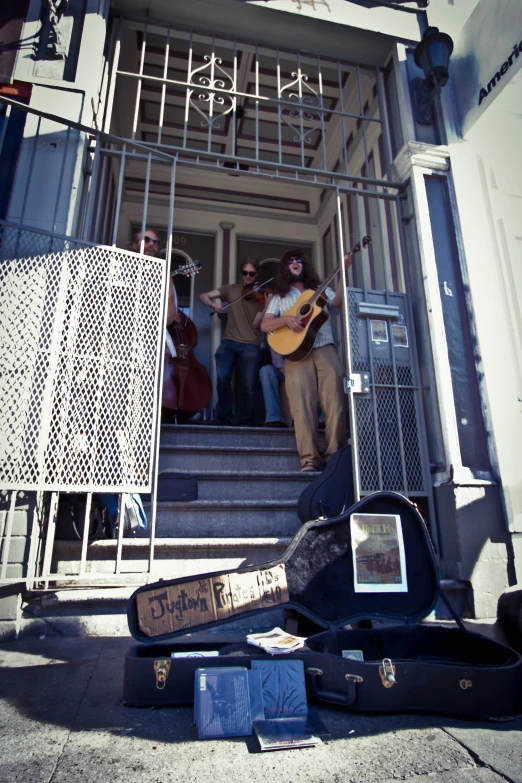 group of people playing instruments out of an apartment doorway