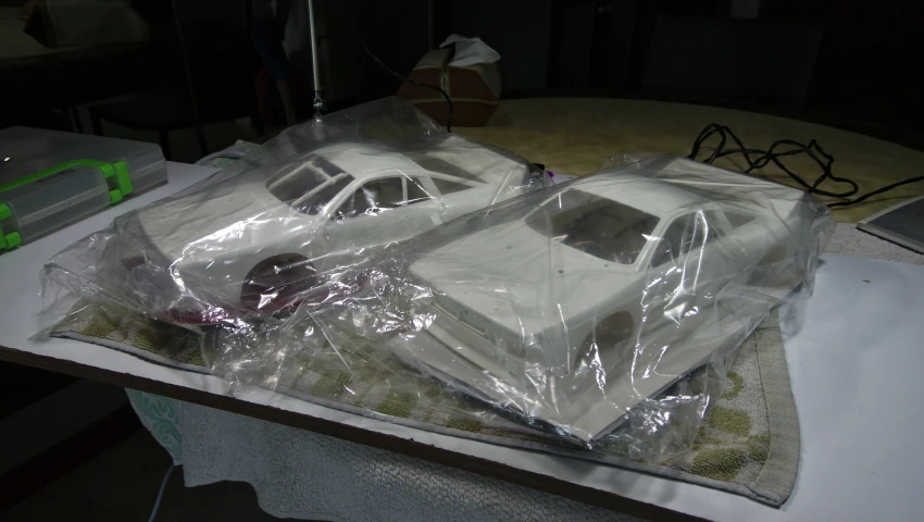 a cake with white cars and a plastic covering