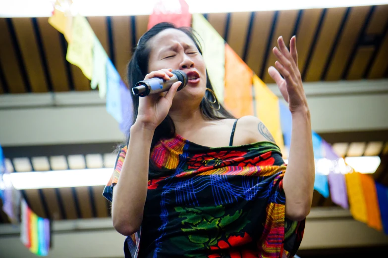 a woman holding a microphone singing into it