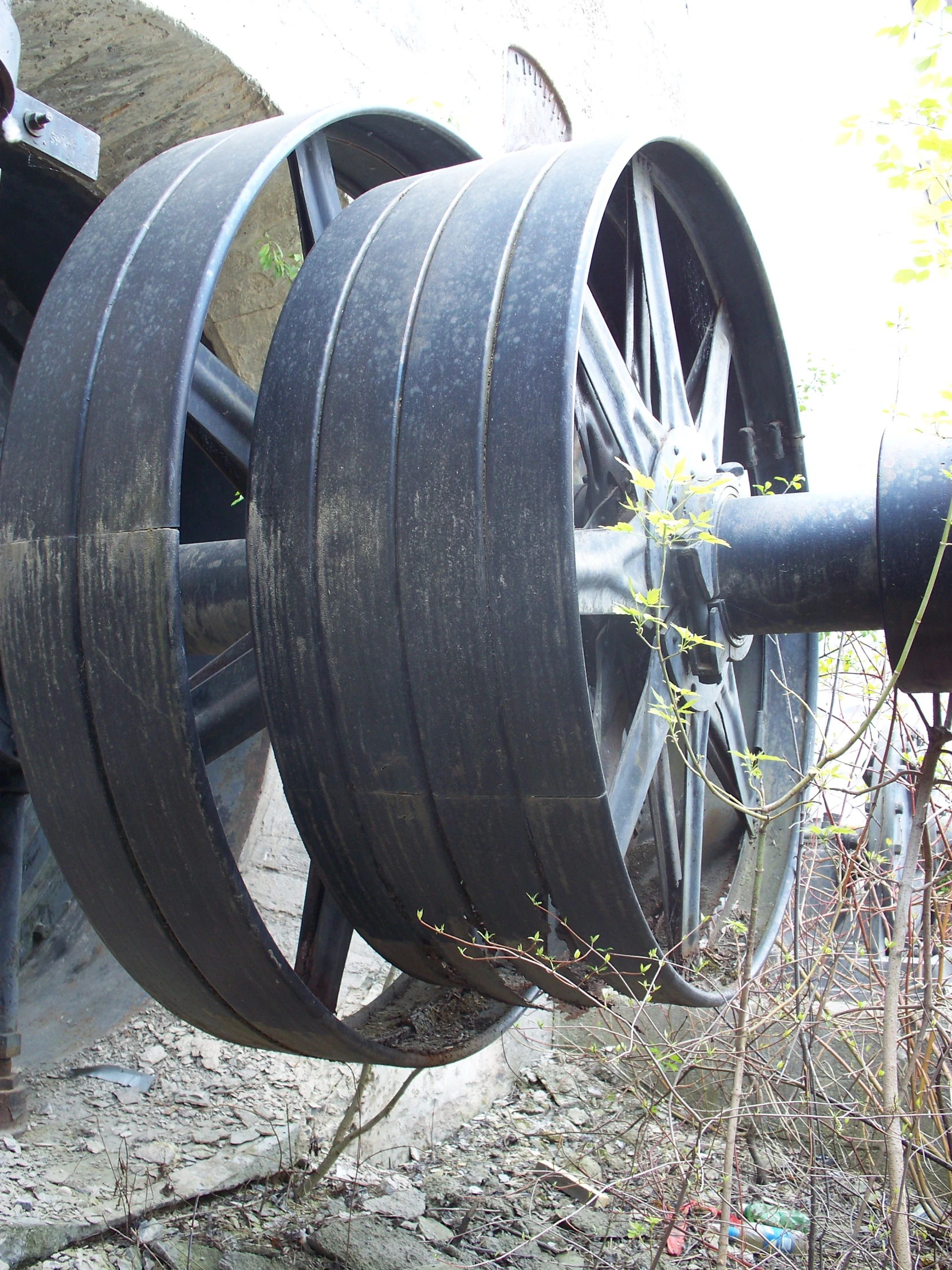 a man standing near a large wheel attached to a pipe