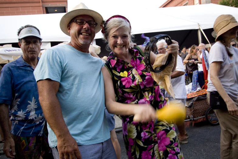 an older couple pose for a po in front of a crowd