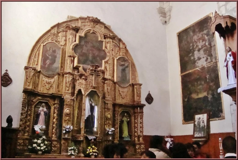 an ornate wooden alter with paintings on the wall