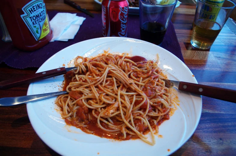 a plate of pasta and a pair of red glasses