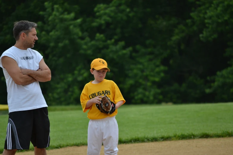 a father and son playing baseball on a field