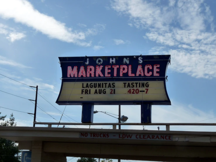 a large marquee sign in the city for johns marketplace