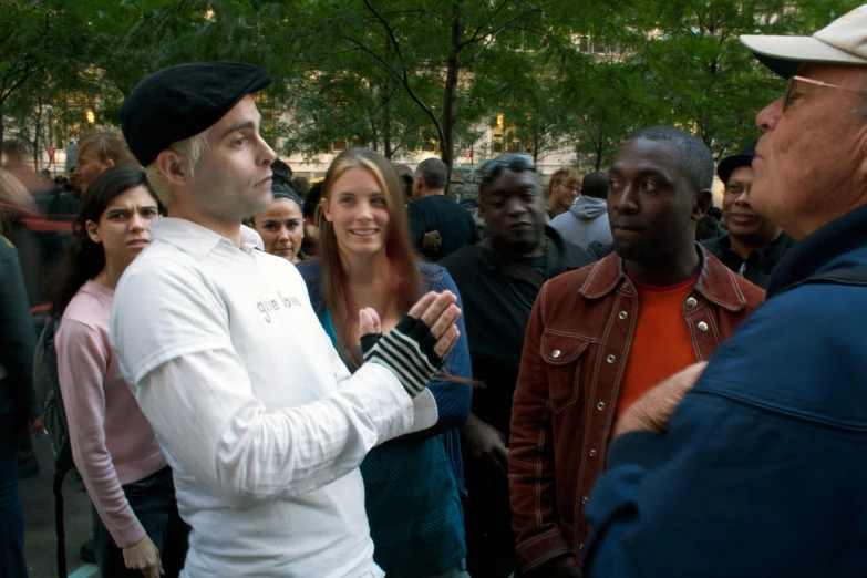 the man is standing in front of many people